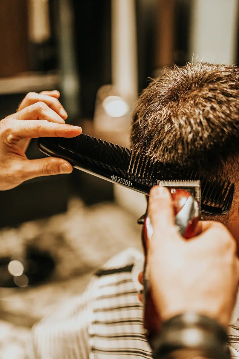 Rambut pelanggan dirapikan dengan sisir dan clipper